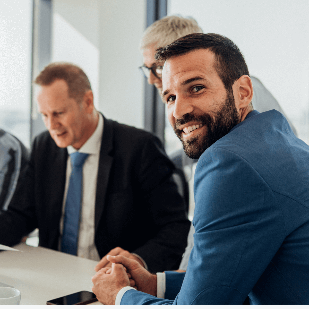 Man smiling whilst in a board meeting 